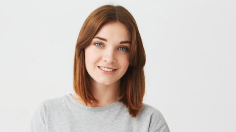 Du har brug for nødprævention Smilende pige med rødt hår og grå sweater